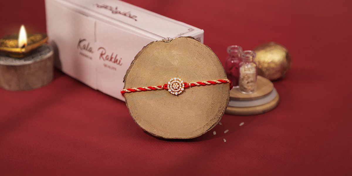 Premium AD Rakhi with red and gold braided thread and diamond-style centerpiece by Kala Rakhi