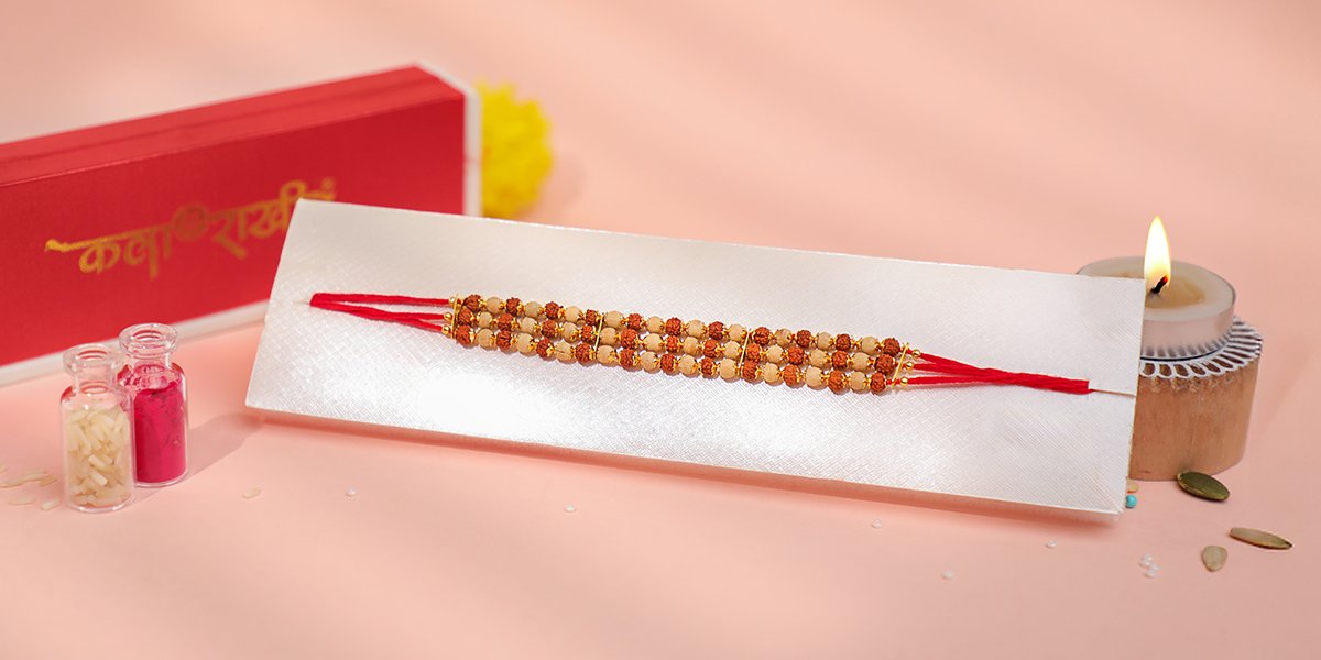 Triple-strand Rudraksh Rakhi with beige beads and red thread – Kala Rakhi