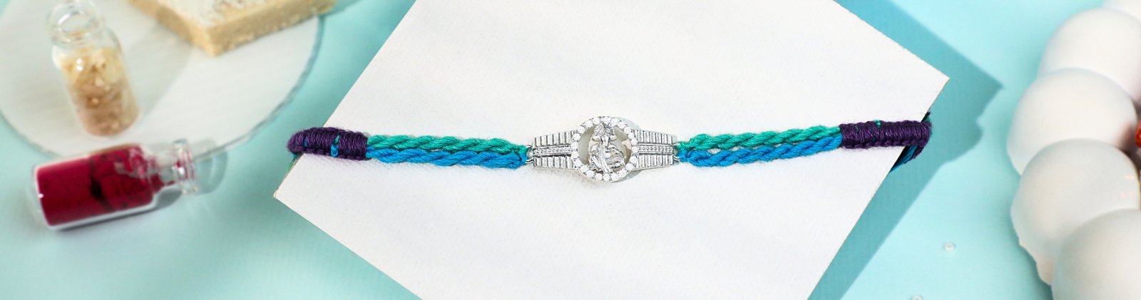 Silver Krishna Rakhi with multicolor thread handcrafted by Kala Rakhi for wholesale buyers